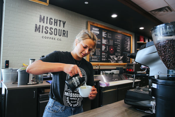 Barista pouring milk into espresso at Mighty Missouri Coffee Co. Coffee Shop