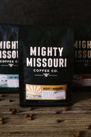 Mighty Missouri Coffee Company beautiful coffee packaging. Mighty Morning, Lake Weekend, and Mighty Mo pictured with coffee beans in the foreground.